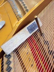 Tapping strings to bridge using wood block